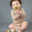 A baby sitting with a collection and using Hevea Natural Rubber Pacifiers from Gimme the Good Stuff 001
