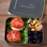 LunchBots Large 3 Compartment Stainless Steel Bento Lunchbox on a wooden table filled with blackberries, pasta salad and tomatoe sandiwches.