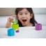 A young girl laughing and playing with a Plan Toys Beehives Wooden Block Game