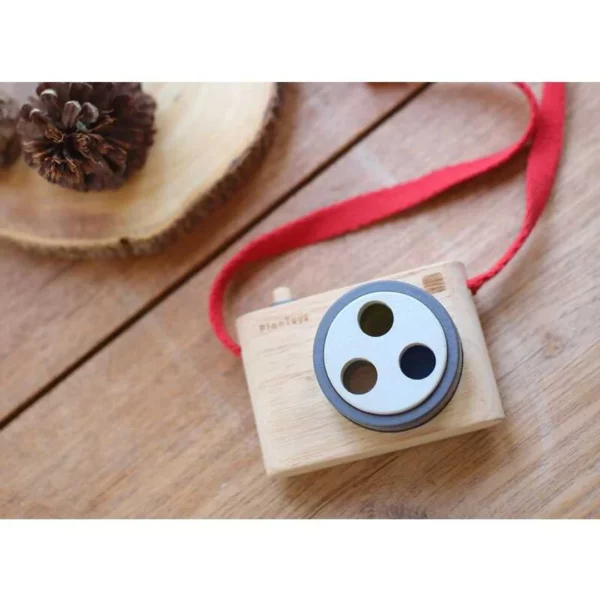 A wooden toy camera sitting on a table.