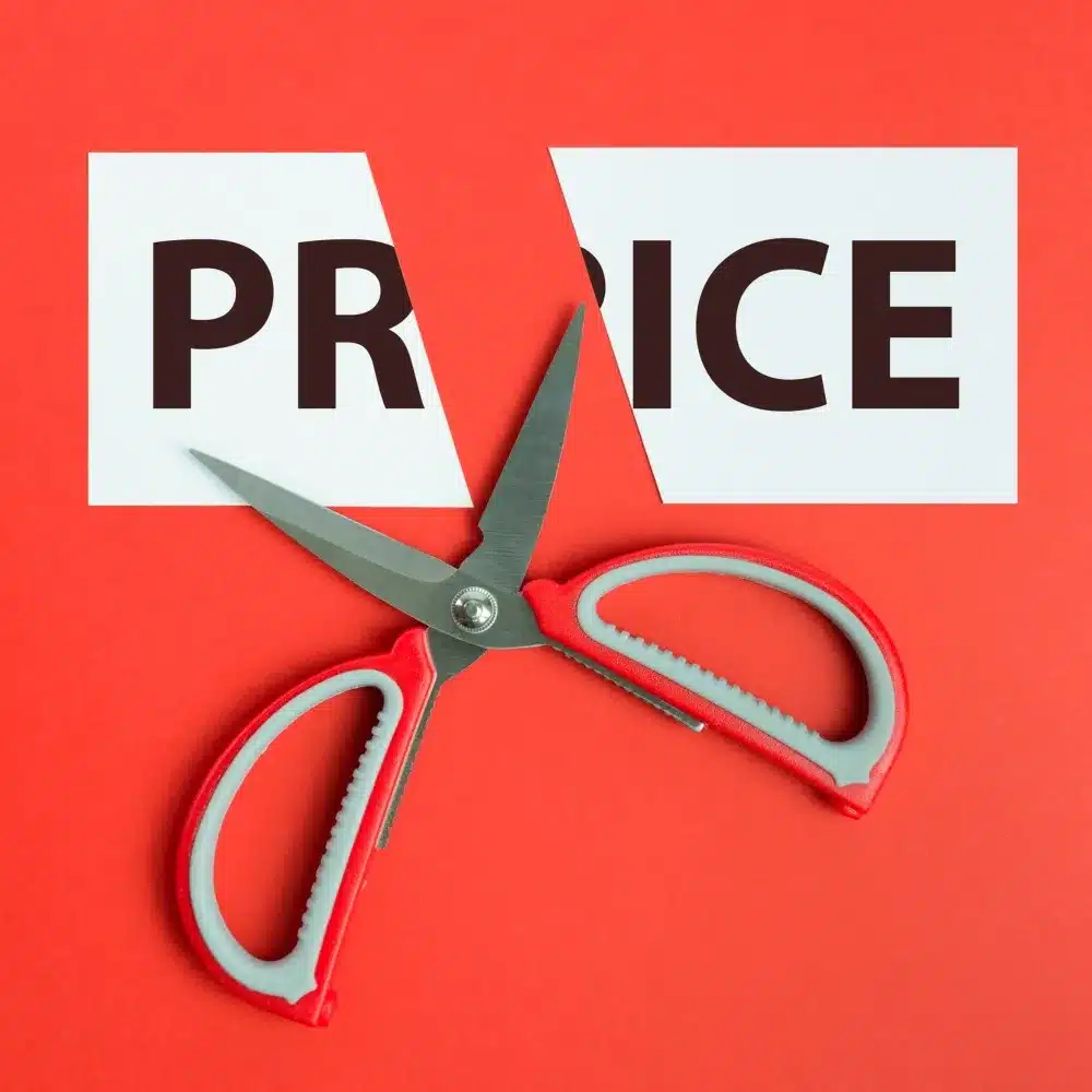 Scissors cutting a sign that says price.